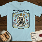 Praise Dog From Whom All Blessings Flow Schnauzer T-Shirt flat lay in Chambray, featuring a vintage tavern sign with a bearded Schnauzer portrait in a gilded oval, hops sprigs, and a ribbon banner, with the words Praise Dog From Whom All Blessings Flow.