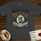 Praise Dog From Whom All Blessings Flow Schnauzer T-Shirt flat lay in Graphite, featuring a vintage tavern sign with a bearded Schnauzer portrait in a gilded oval, hops sprigs, and a ribbon banner, with the words Praise Dog From Whom All Blessings Flow.