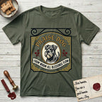 Praise Dog From Whom All Blessings Flow Schnauzer T-Shirt flat lay in Heather Military Green, featuring a vintage tavern sign with a bearded Schnauzer portrait in a gilded oval, hops sprigs, and a ribbon banner, with the words Praise Dog From Whom All Blessings Flow.