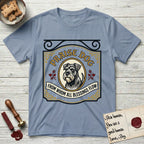 Praise Dog From Whom All Blessings Flow Schnauzer T-Shirt flat lay in Stone Blue, featuring a vintage tavern sign with a bearded Schnauzer portrait in a gilded oval, hops sprigs, and a ribbon banner, with the words Praise Dog From Whom All Blessings Flow.