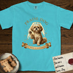 Praise Dog From Whom All Blessings Flow Shih Tzu T-Shirt flat lay in Lagoon Blue, featuring an old-master devotional oil painting of a Shih Tzu seated with one paw raised in blessing, a floating gold halo and streaming light, a shower of small gold blessings, and gilt "Praise Dog From Whom All Blessings Flow" lettering on a ribbon scroll.