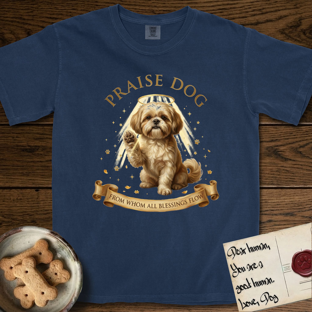 Praise Dog From Whom All Blessings Flow Shih Tzu T-Shirt flat lay in True Navy, featuring an old-master devotional oil painting of a Shih Tzu seated with one paw raised in blessing, a floating gold halo and streaming light, a shower of small gold blessings, and gilt "Praise Dog From Whom All Blessings Flow" lettering on a ribbon scroll.