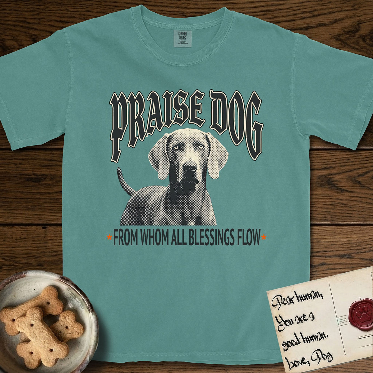 Praise Dog From Whom All Blessings Flow Weimaraner T-Shirt flat lay in Blue Spruce, featuring a gothic halftone poster with a Weimaraner staring straight ahead beneath heavy blackletter lettering and the words Praise Dog From Whom All Blessings Flow.