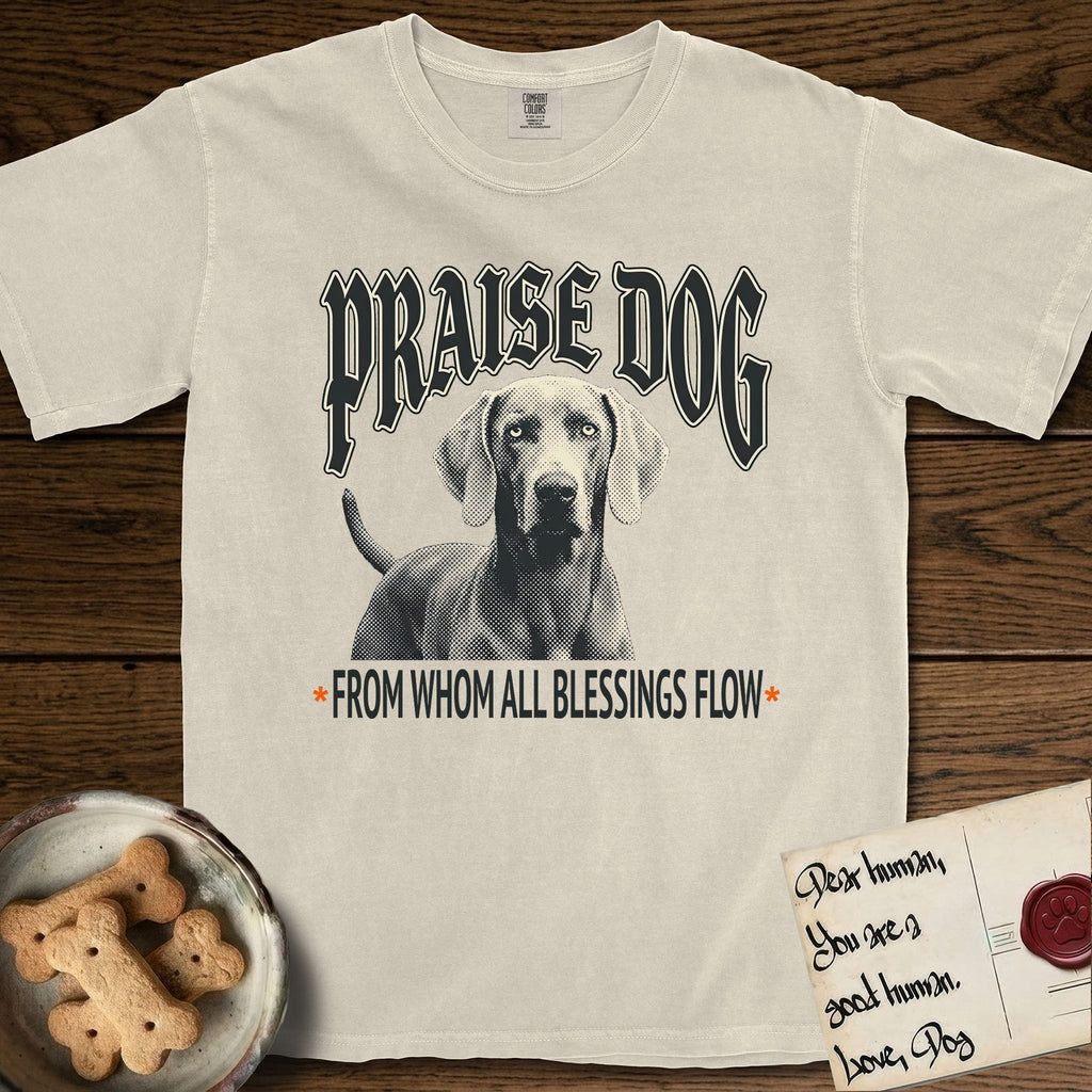 Praise Dog From Whom All Blessings Flow Weimaraner T-Shirt flat lay in Ivory, featuring a gothic halftone poster with a Weimaraner staring straight ahead beneath heavy blackletter lettering and the words Praise Dog From Whom All Blessings Flow.