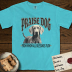Praise Dog From Whom All Blessings Flow Weimaraner T-Shirt flat lay in Lagoon Blue, featuring a gothic halftone poster with a Weimaraner staring straight ahead beneath heavy blackletter lettering and the words Praise Dog From Whom All Blessings Flow.