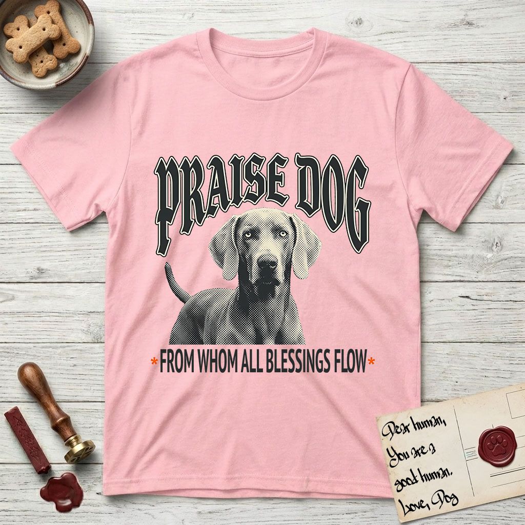 Praise Dog From Whom All Blessings Flow Weimaraner T-Shirt flat lay in Light Pink, featuring a gothic halftone poster with a Weimaraner staring straight ahead beneath heavy blackletter lettering and the words Praise Dog From Whom All Blessings Flow.