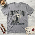 Praise Dog From Whom All Blessings Flow Weimaraner T-Shirt flat lay in Sport Grey, featuring a gothic halftone poster with a Weimaraner staring straight ahead beneath heavy blackletter lettering and the words Praise Dog From Whom All Blessings Flow.