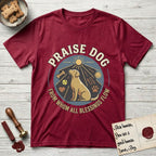 Praise Dog From Whom All Blessings Flow Yellow Lab T-Shirt flat lay in Antique Cherry Red, featuring a warm vintage circular emblem with an upward-gazing Yellow Lab, a sunburst, and a devotional border of small hearts and stars.