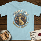 Praise Dog From Whom All Blessings Flow Yellow Lab T-Shirt flat lay in Chambray, featuring a warm vintage circular emblem with an upward-gazing Yellow Lab, a sunburst, and a devotional border of small hearts and stars.