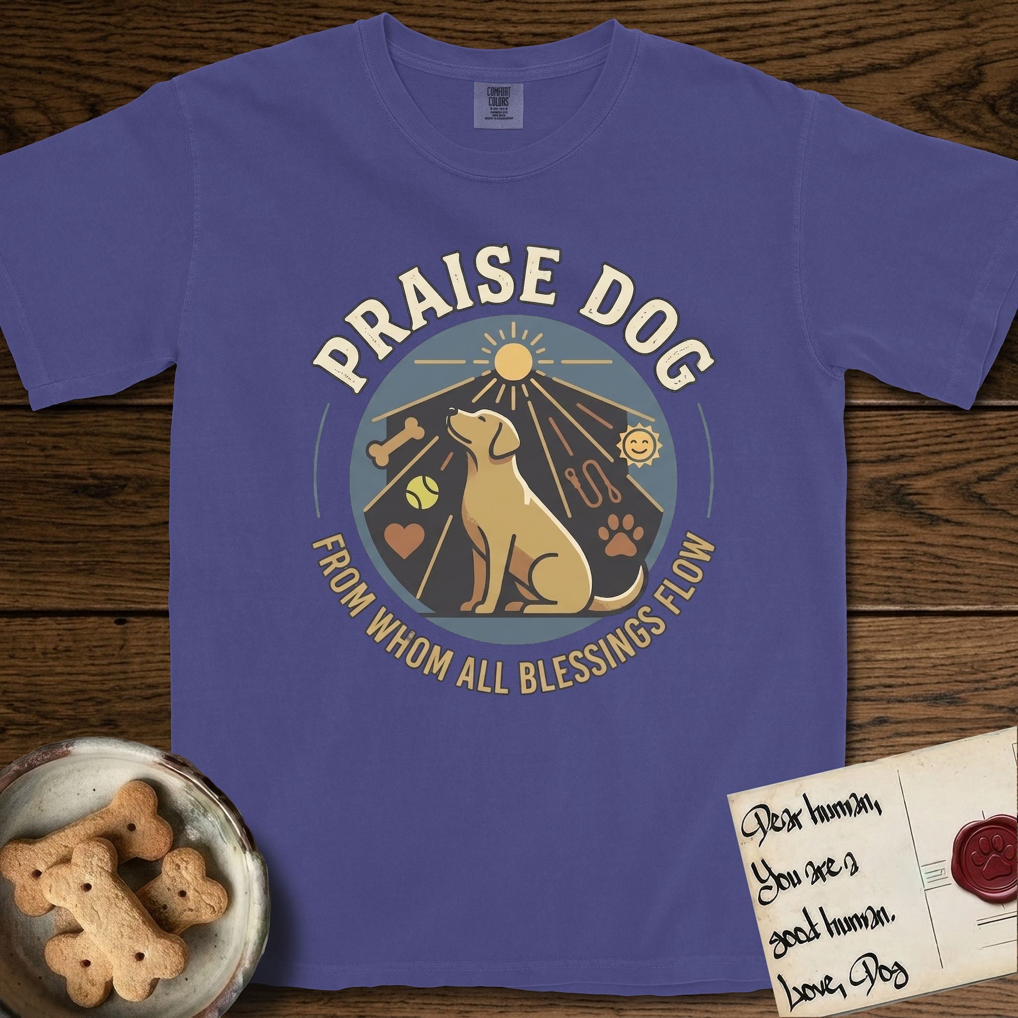 Praise Dog From Whom All Blessings Flow Yellow Lab T-Shirt flat lay in Grape, featuring a warm vintage circular emblem with an upward-gazing Yellow Lab, a sunburst, and a devotional border of small hearts and stars.