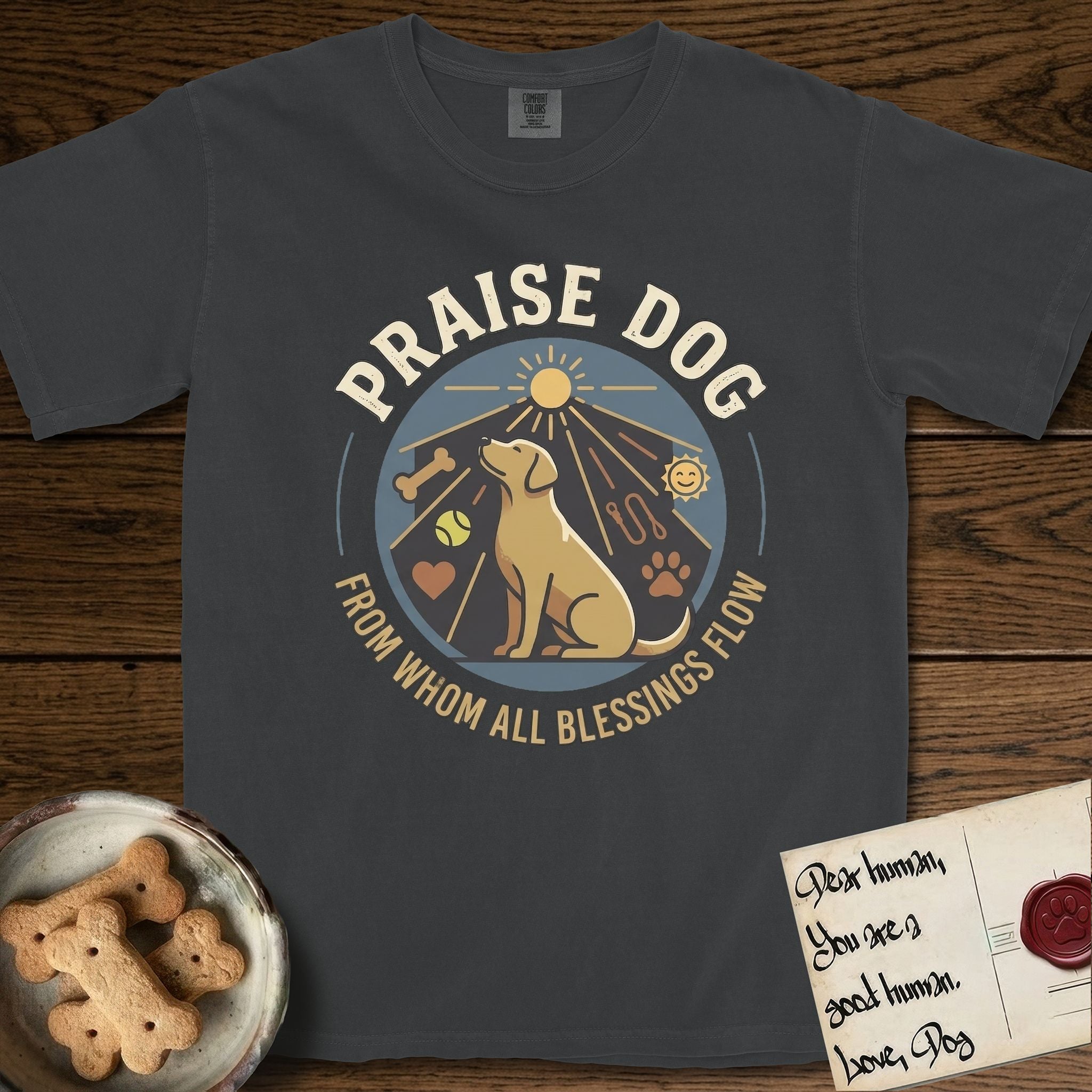Praise Dog From Whom All Blessings Flow Yellow Lab T-Shirt flat lay in Graphite, featuring a warm vintage circular emblem with an upward-gazing Yellow Lab, a sunburst, and a devotional border of small hearts and stars.