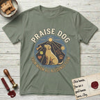 Praise Dog From Whom All Blessings Flow Yellow Lab T-Shirt flat lay in Sage, featuring a warm vintage circular emblem with an upward-gazing Yellow Lab, a sunburst, and a devotional border of small hearts and stars.