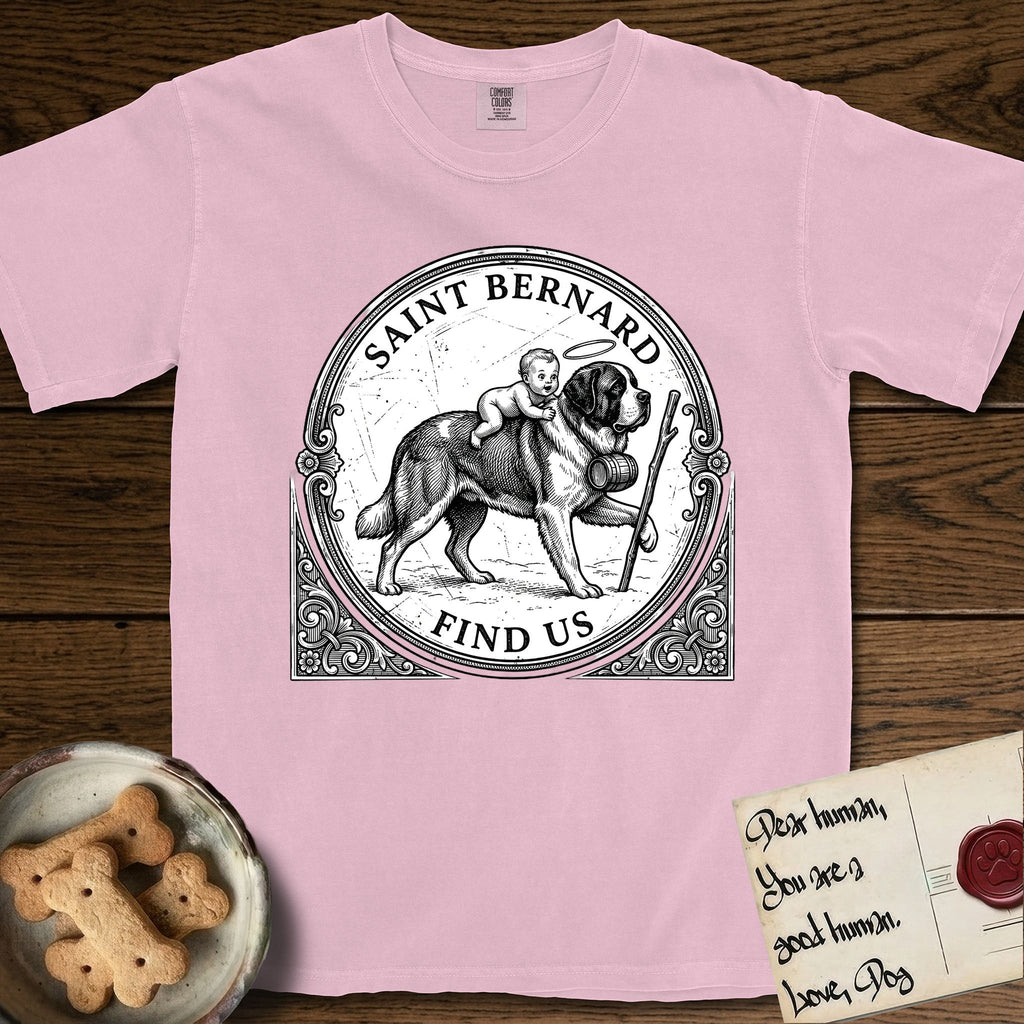 Patron Saint Medallion Saint Bernard T-Shirt flat lay in Blossom, featuring a vintage engraving coin medallion of a haloed Saint Bernard carrying a child across a mountain pass, with the petition FIND US.