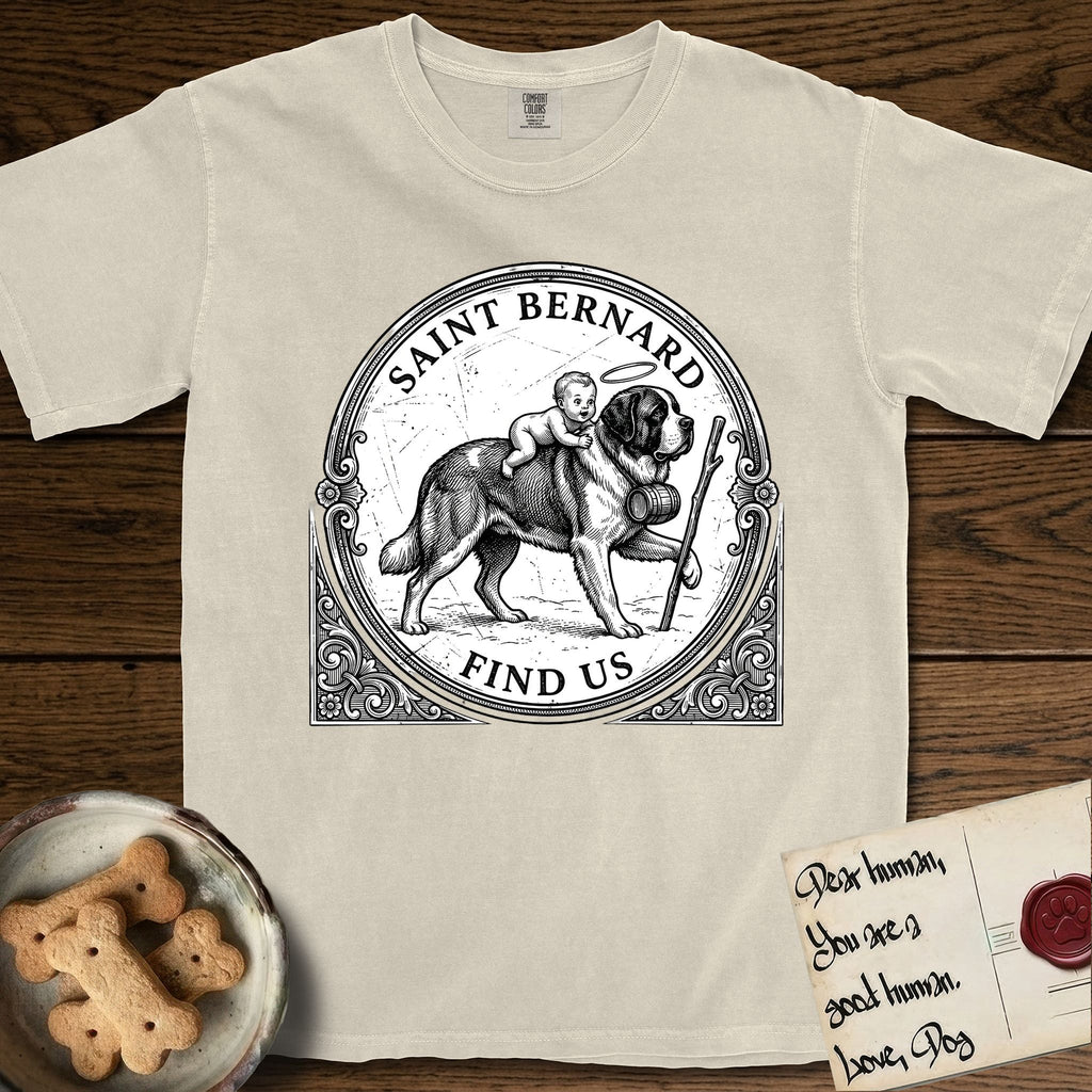 Patron Saint Medallion Saint Bernard T-Shirt flat lay in Ivory, featuring a vintage engraving coin medallion of a haloed Saint Bernard carrying a child across a mountain pass, with the petition FIND US.