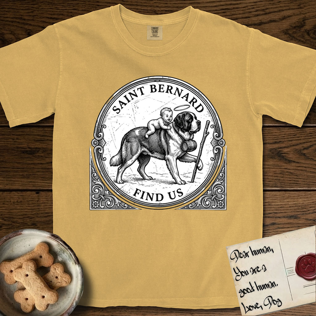 Patron Saint Medallion Saint Bernard T-Shirt flat lay in Mustard, featuring a vintage engraving coin medallion of a haloed Saint Bernard carrying a child across a mountain pass, with the petition FIND US.