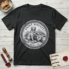 Patron Saint Medallion Saint Biscuit T-Shirt flat lay in Black, featuring a vintage engraving coin medallion of a haloed Golden Retriever with a devotee resting against her and an open book, with the petition HEAL US.