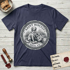 Patron Saint Medallion Saint Biscuit T-Shirt flat lay in Navy, featuring a vintage engraving coin medallion of a haloed Golden Retriever with a devotee resting against her and an open book, with the petition HEAL US.