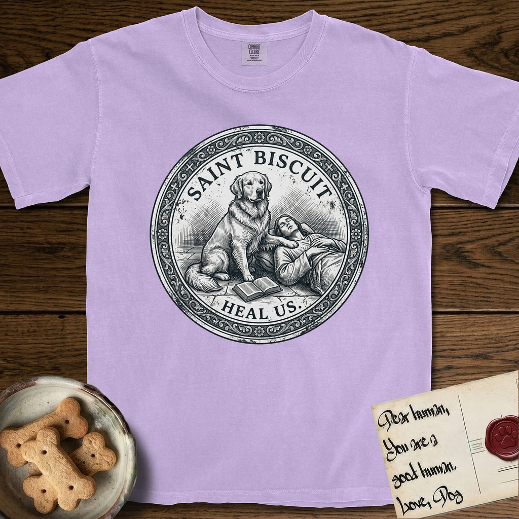 Patron Saint Medallion Saint Biscuit T-Shirt flat lay in Orchid, featuring a vintage engraving coin medallion of a haloed Golden Retriever with a devotee resting against her and an open book, with the petition HEAL US.