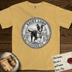 Patron Saint Medallion Saint Lobo T-Shirt flat lay in Mustard, featuring a vintage engraving coin medallion of haloed Saint Lobo running across open ground, with the petition GATHER US.