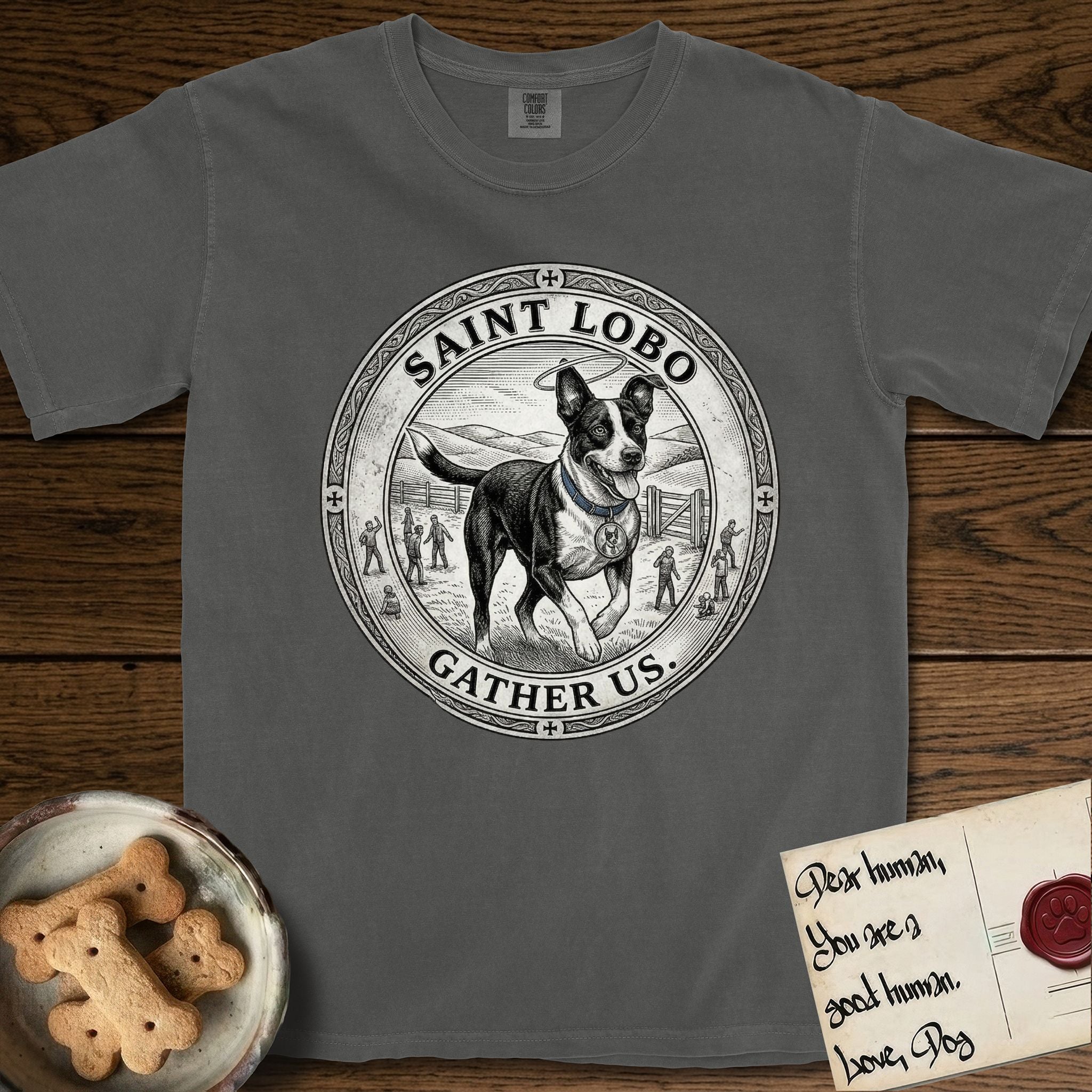 Patron Saint Medallion Saint Lobo T-Shirt flat lay in Pepper, featuring a vintage engraving coin medallion of haloed Saint Lobo running across open ground, with the petition GATHER US.