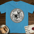 Patron Saint Medallion Saint Lobo T-Shirt flat lay in Royal Caribe, featuring a vintage engraving coin medallion of haloed Saint Lobo running across open ground, with the petition GATHER US.