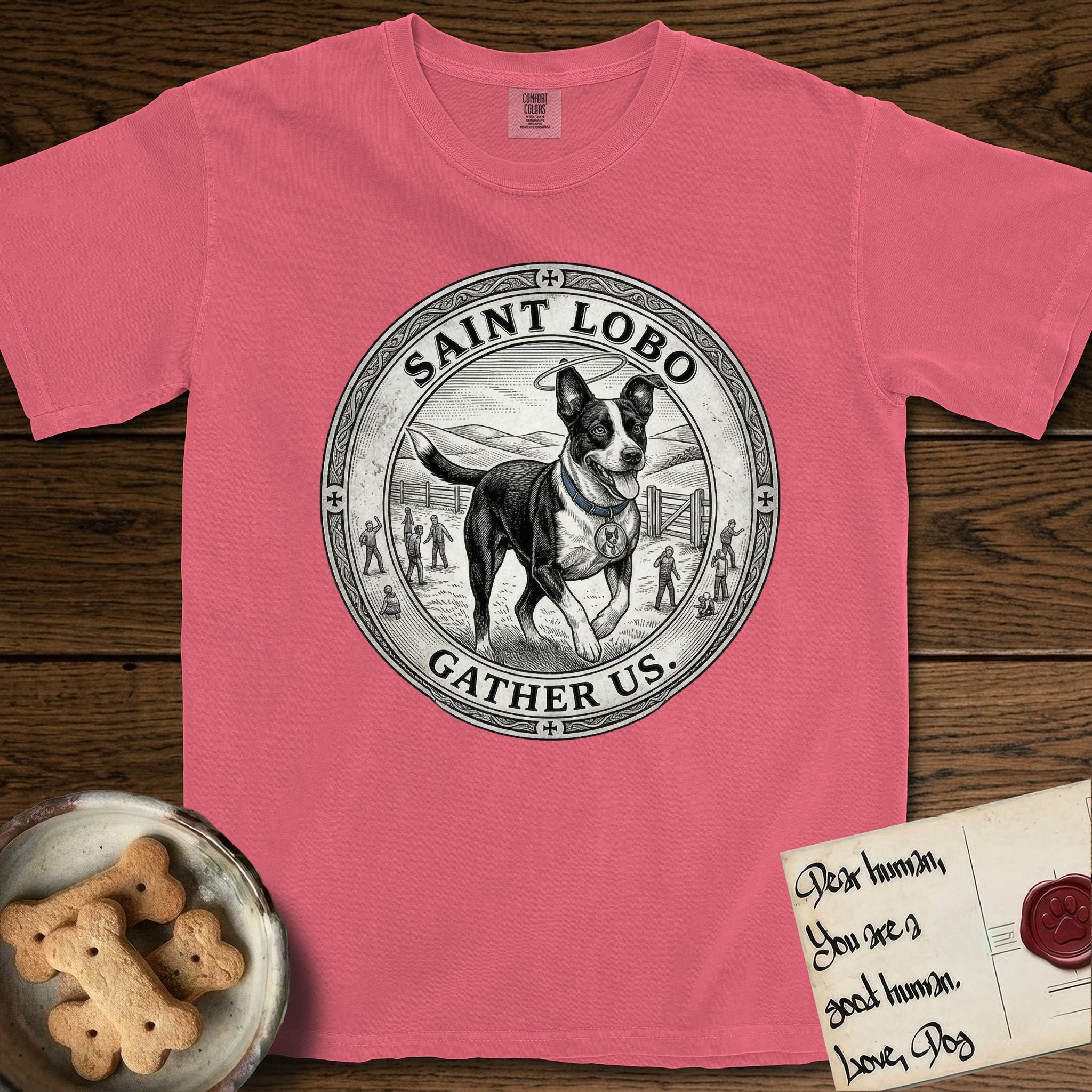 Patron Saint Medallion Saint Lobo T-Shirt flat lay in Watermelon, featuring a vintage engraving coin medallion of haloed Saint Lobo running across open ground, with the petition GATHER US.