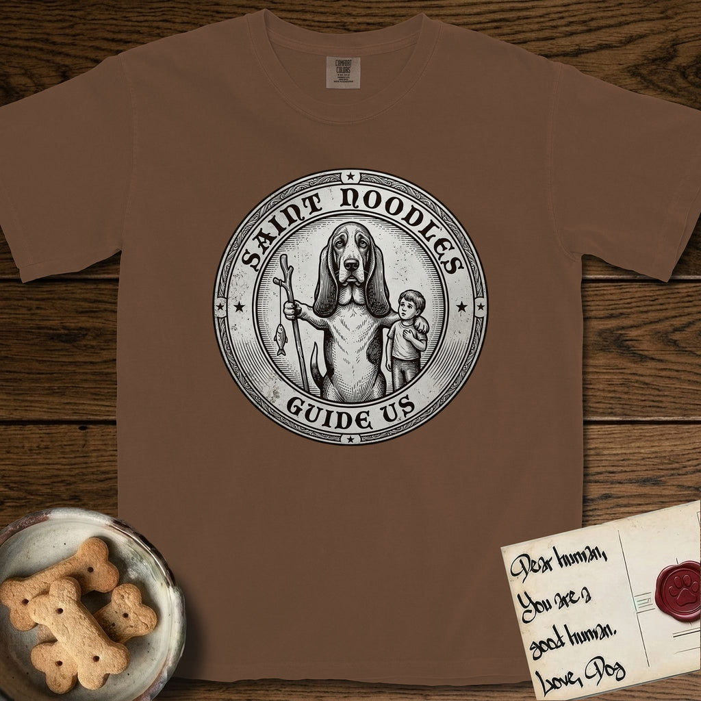 Patron Saint Medallion Saint Noodles T-Shirt flat lay in Espresso, featuring a vintage engraving coin medallion of a haloed Basset Hound with a staff and a child at her side, with the petition GUIDE US.
