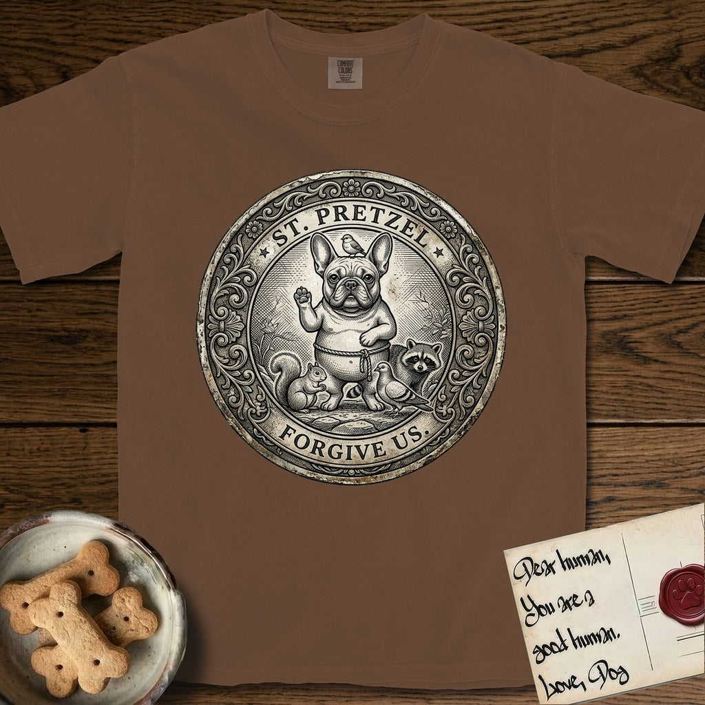 Patron Saint Medallion Saint Pretzel T-Shirt flat lay in Espresso, featuring an ornate vintage engraving coin medallion of a haloed French Bulldog raising one paw, a small bird on his head and woodland animals at his feet, with the petition FORGIVE US.