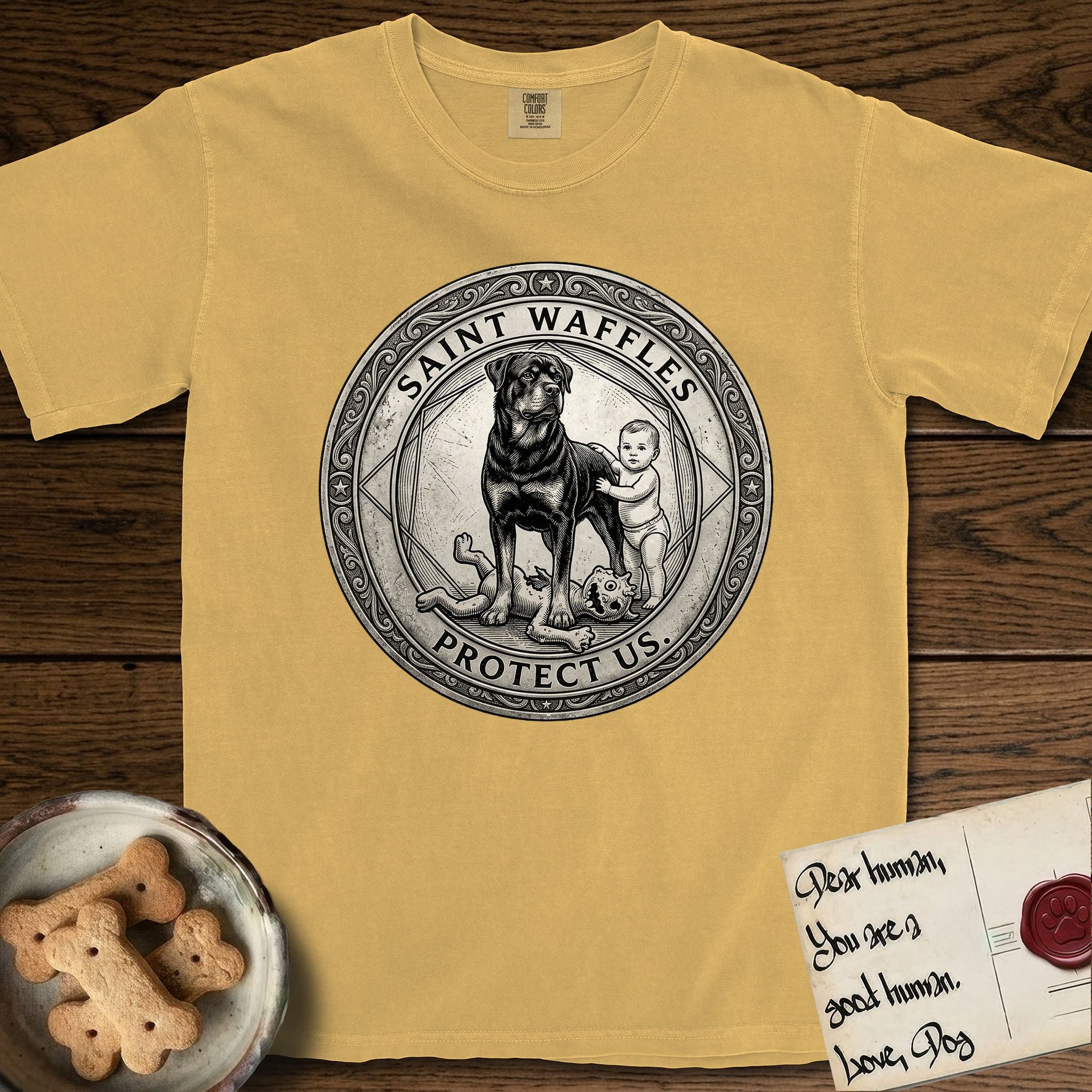Patron Saint Medallion Saint Waffles T-Shirt flat lay in Mustard, featuring a vintage engraving coin medallion of a haloed Rottweiler standing guard over a small child, with the petition PROTECT US.