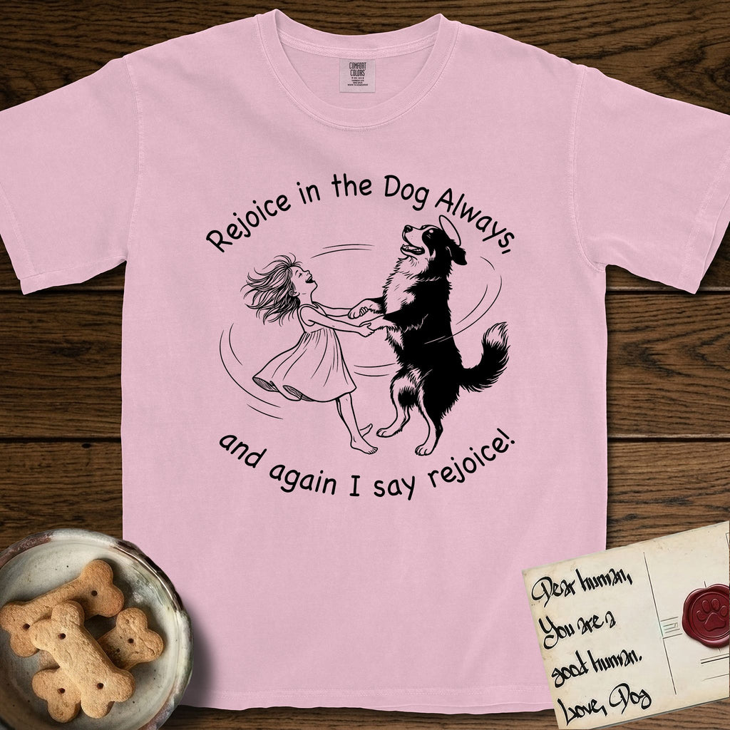 Rejoice in the Dog Bernese Mountain Dog T-Shirt flat lay in Blossom, featuring a sparse pen-and-ink illustration of a girl and her Bernese Mountain Dog spinning together, her feet lifting off the ground.