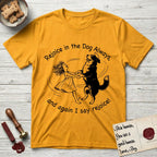 Rejoice in the Dog Bernese Mountain Dog T-Shirt flat lay in Gold, featuring a sparse pen-and-ink illustration of a girl and her Bernese Mountain Dog spinning together, her feet lifting off the ground.