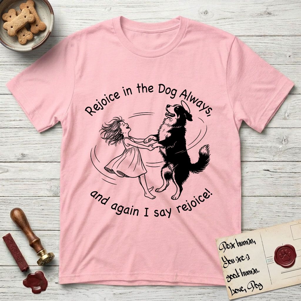 Rejoice in the Dog Bernese Mountain Dog T-Shirt flat lay in Light Pink, featuring a sparse pen-and-ink illustration of a girl and her Bernese Mountain Dog spinning together, her feet lifting off the ground.