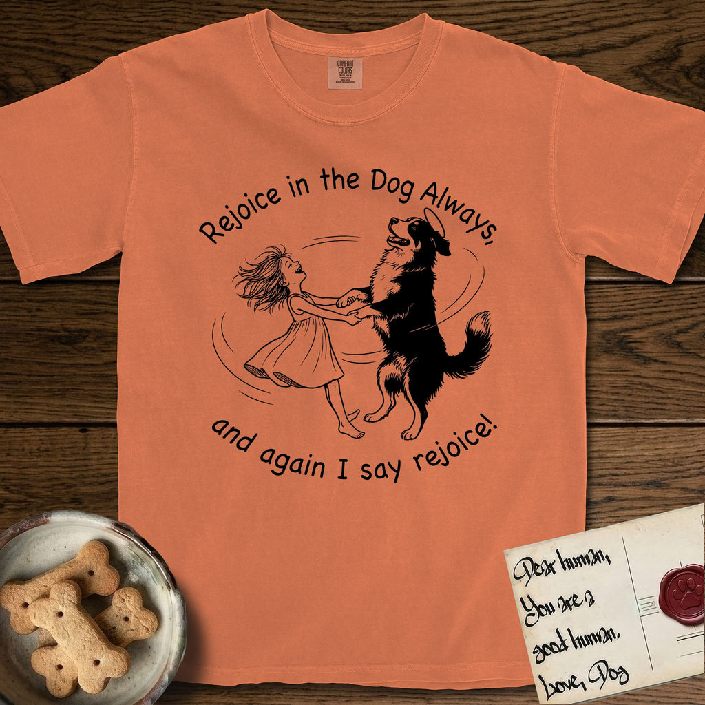 Rejoice in the Dog Bernese Mountain Dog T-Shirt flat lay in Melon, featuring a sparse pen-and-ink illustration of a girl and her Bernese Mountain Dog spinning together, her feet lifting off the ground.