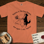 Rejoice in the Dog Bernese Mountain Dog T-Shirt flat lay in Melon, featuring a sparse pen-and-ink illustration of a girl and her Bernese Mountain Dog spinning together, her feet lifting off the ground.