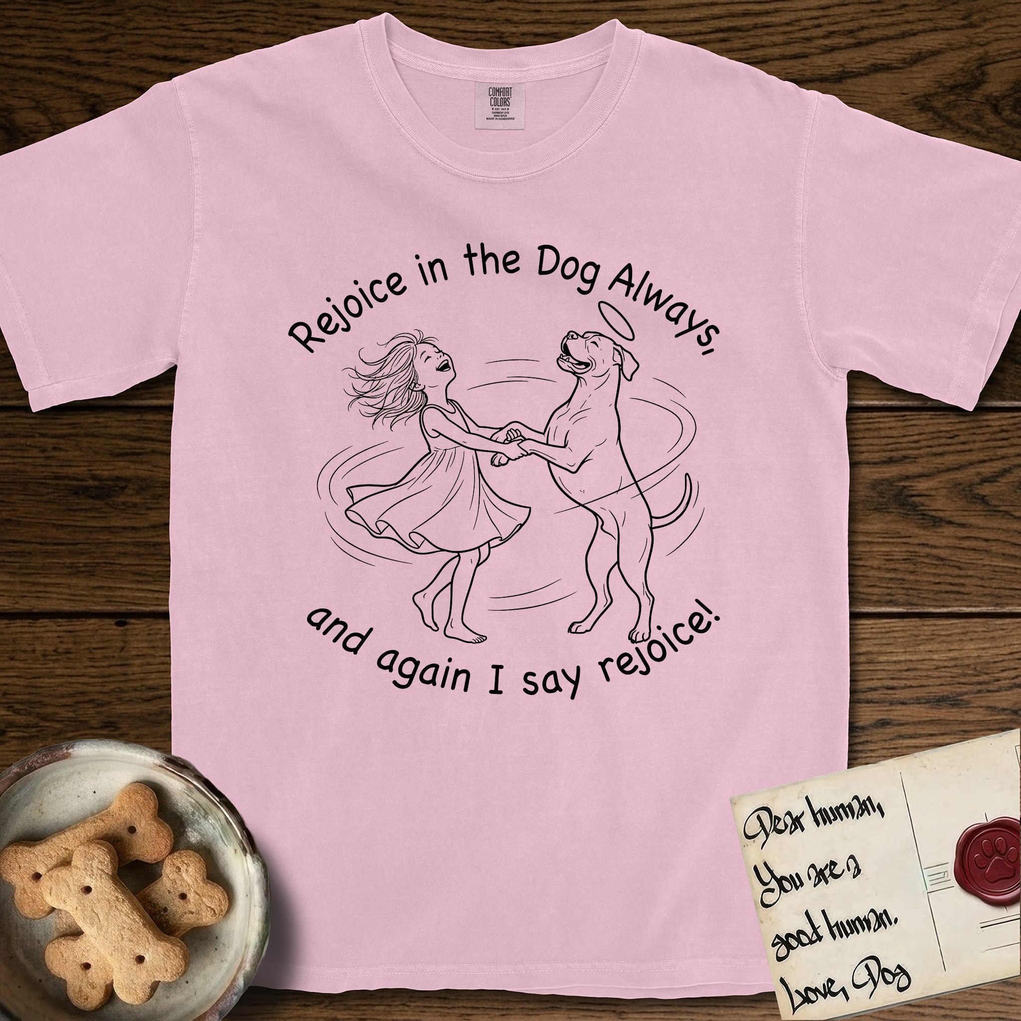 Rejoice in the Dog Boxer T-Shirt flat lay in Blossom, featuring a sparse pen-and-ink illustration of a girl and her Boxer dancing on his hind legs, both heads thrown back in joy.