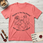 Rejoice in the Dog Boxer T-Shirt flat lay in Coral Silk, featuring a sparse pen-and-ink illustration of a girl and her Boxer dancing on his hind legs, both heads thrown back in joy.