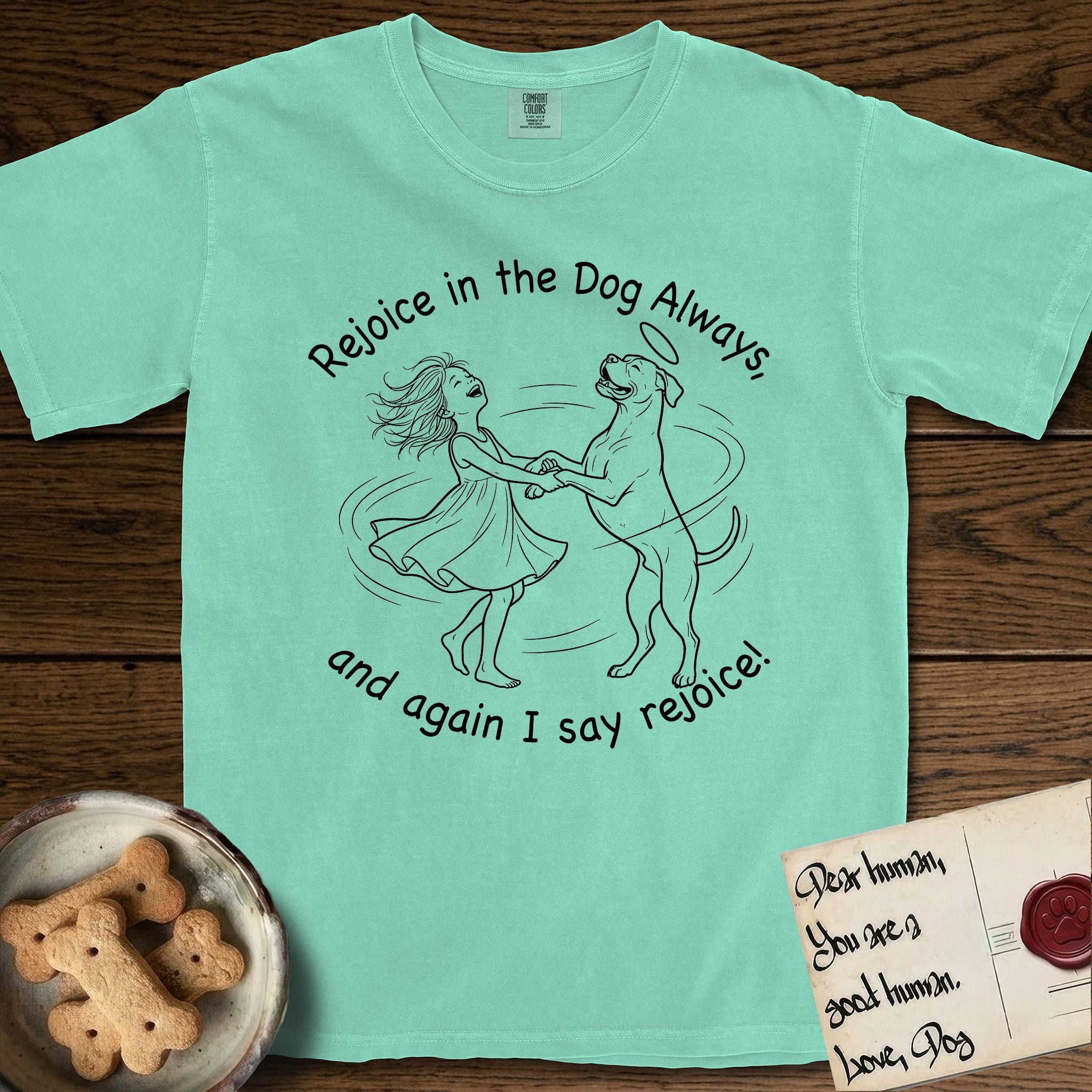 Rejoice in the Dog Boxer T-Shirt flat lay in Island Reef, featuring a sparse pen-and-ink illustration of a girl and her Boxer dancing on his hind legs, both heads thrown back in joy.