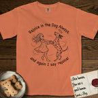 Rejoice in the Dog Dalmatian T-Shirt flat lay in Melon, featuring a sparse pen-and-ink illustration of a girl and her Dalmatian spinning together, both heads thrown back in joy.