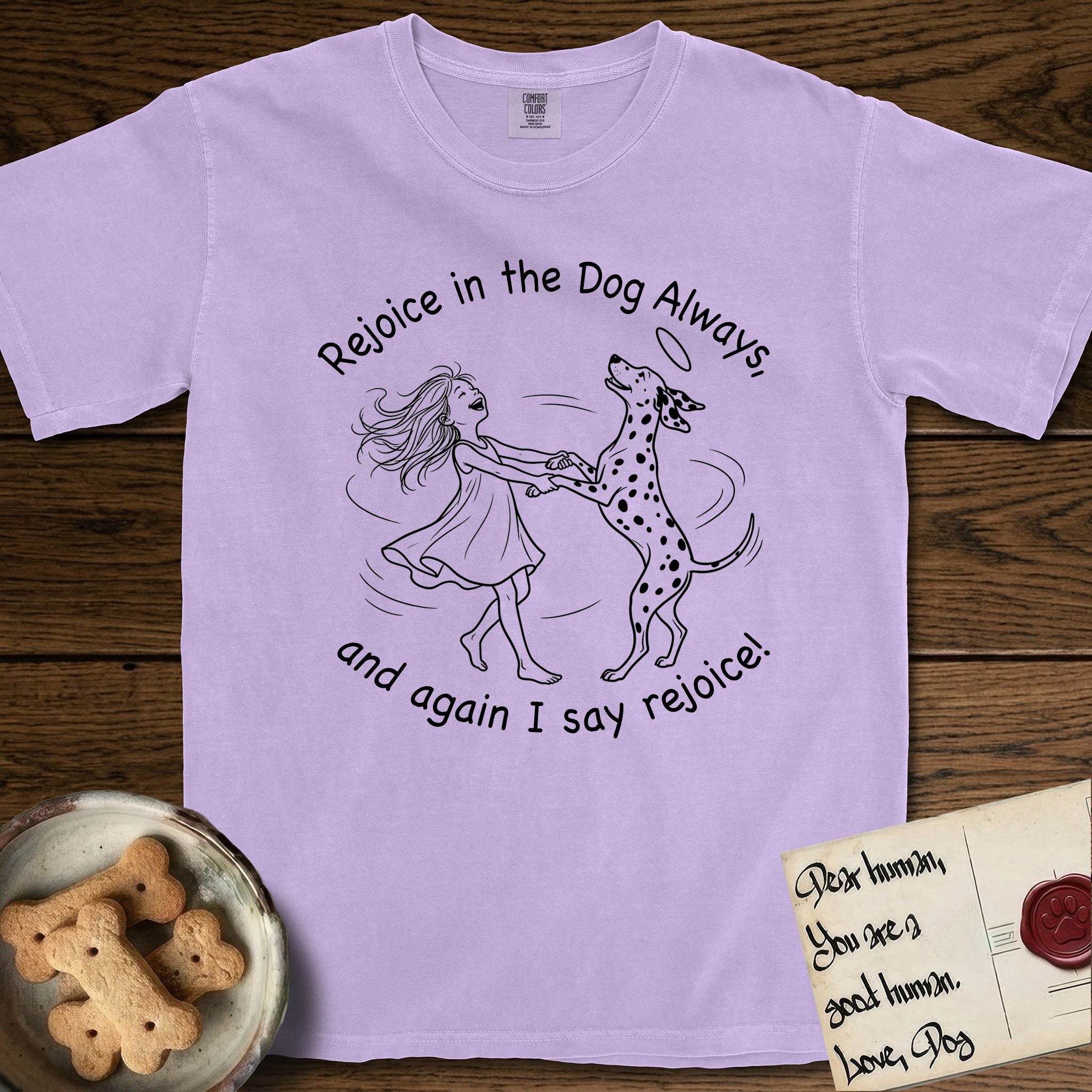 Rejoice in the Dog Dalmatian T-Shirt flat lay in Orchid, featuring a sparse pen-and-ink illustration of a girl and her Dalmatian spinning together, both heads thrown back in joy.
