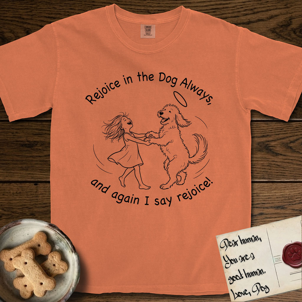Rejoice in the Dog Goldendoodle T-Shirt flat lay in Melon, featuring a sparse pen-and-ink illustration of a girl and her Goldendoodle dancing together, fur flying, both heads thrown back.