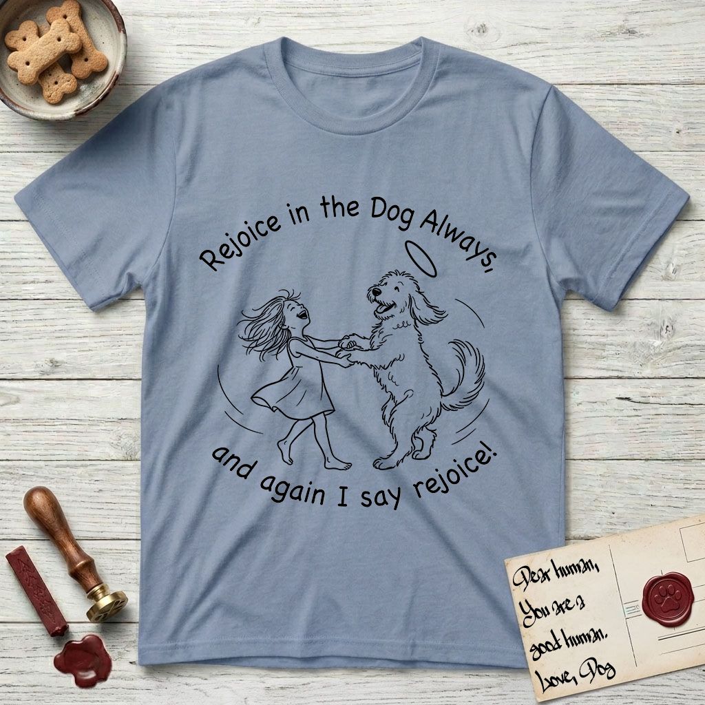 Rejoice in the Dog Goldendoodle T-Shirt flat lay in Stone Blue, featuring a sparse pen-and-ink illustration of a girl and her Goldendoodle dancing together, fur flying, both heads thrown back.