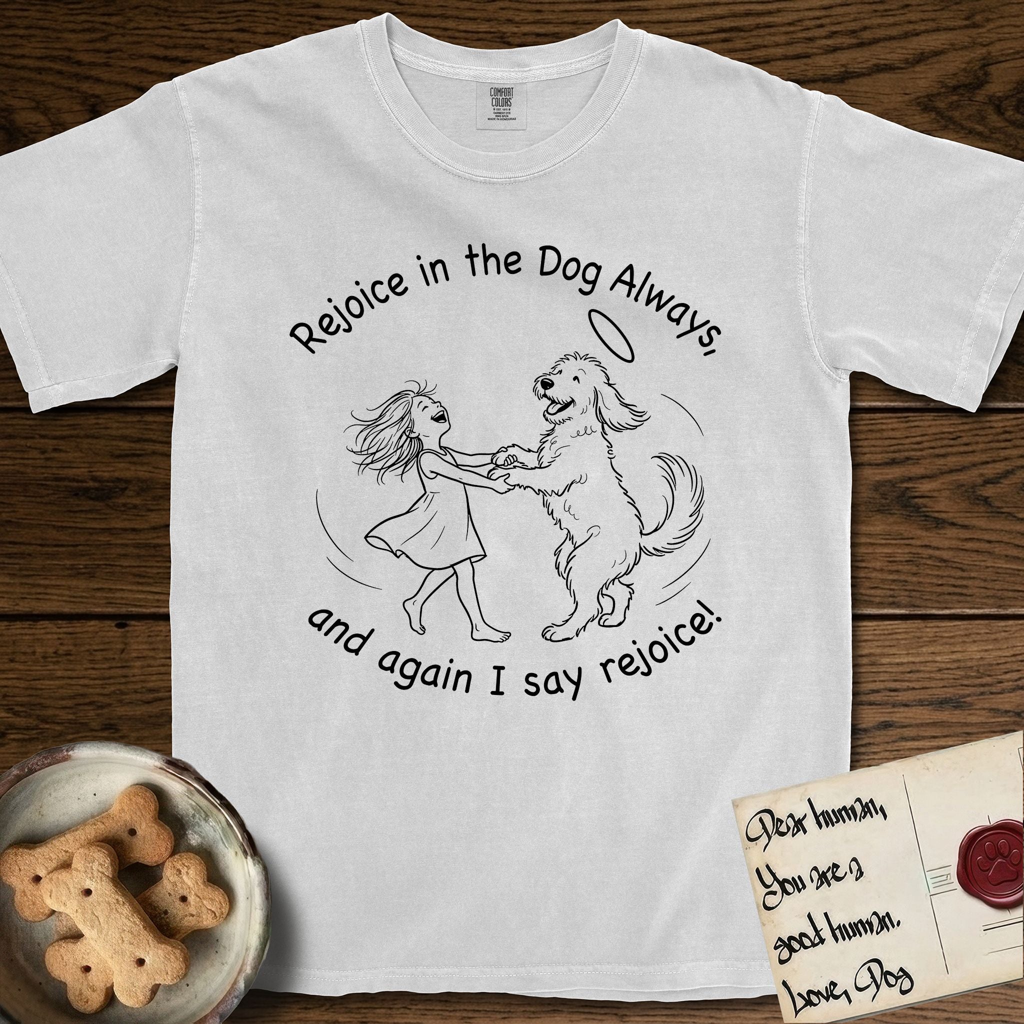 Rejoice in the Dog Goldendoodle T-Shirt flat lay in White, featuring a sparse pen-and-ink illustration of a girl and her Goldendoodle dancing together, fur flying, both heads thrown back.