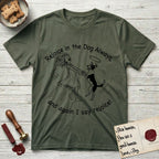 Rejoice in the Dog Lobo T-Shirt flat lay in Heather Military Green, featuring a sparse pen-and-ink illustration of a girl and her haloed Dog Lobo spinning together, hands and paws clasped.