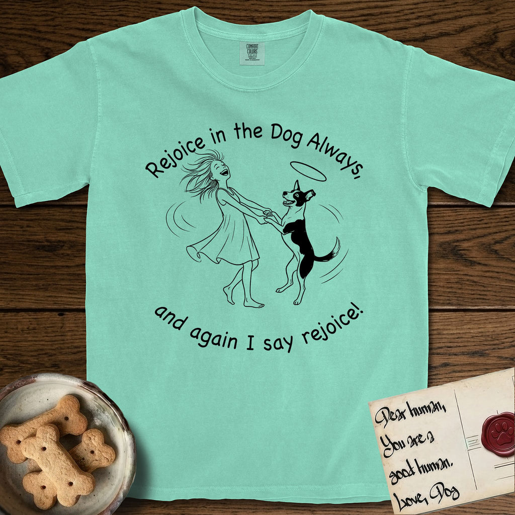 Rejoice in the Dog Lobo T-Shirt flat lay in Island Reef, featuring a sparse pen-and-ink illustration of a girl and her haloed Dog Lobo spinning together, hands and paws clasped.