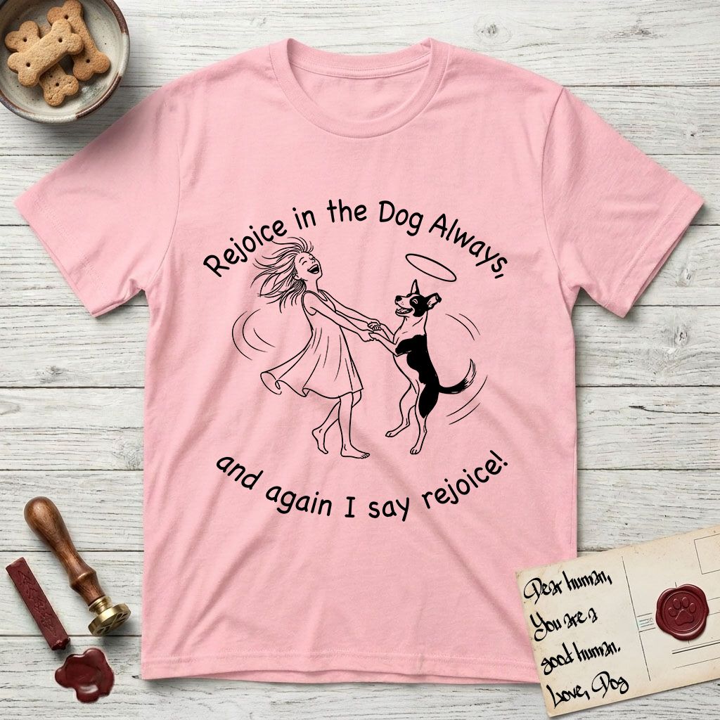 Rejoice in the Dog Lobo T-Shirt flat lay in Light Pink, featuring a sparse pen-and-ink illustration of a girl and her haloed Dog Lobo spinning together, hands and paws clasped.