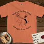 Rejoice in the Dog Lobo T-Shirt flat lay in Melon, featuring a sparse pen-and-ink illustration of a girl and her haloed Dog Lobo spinning together, hands and paws clasped.