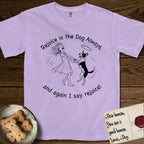 Rejoice in the Dog Lobo T-Shirt flat lay in Orchid, featuring a sparse pen-and-ink illustration of a girl and her haloed Dog Lobo spinning together, hands and paws clasped.