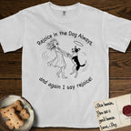 Rejoice in the Dog Lobo T-Shirt flat lay in White, featuring a sparse pen-and-ink illustration of a girl and her haloed Dog Lobo spinning together, hands and paws clasped.