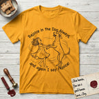 Rejoice in the Dog Rhodesian Ridgeback T-Shirt flat lay in Gold, featuring a sparse pen-and-ink illustration of a girl and her Rhodesian Ridgeback spinning together, hands and paws clasped.