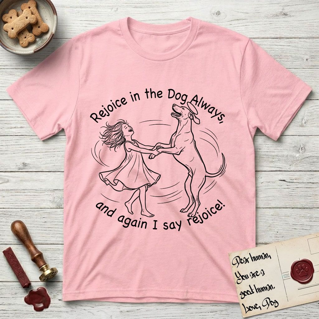 Rejoice in the Dog Rhodesian Ridgeback T-Shirt flat lay in Light Pink, featuring a sparse pen-and-ink illustration of a girl and her Rhodesian Ridgeback spinning together, hands and paws clasped.